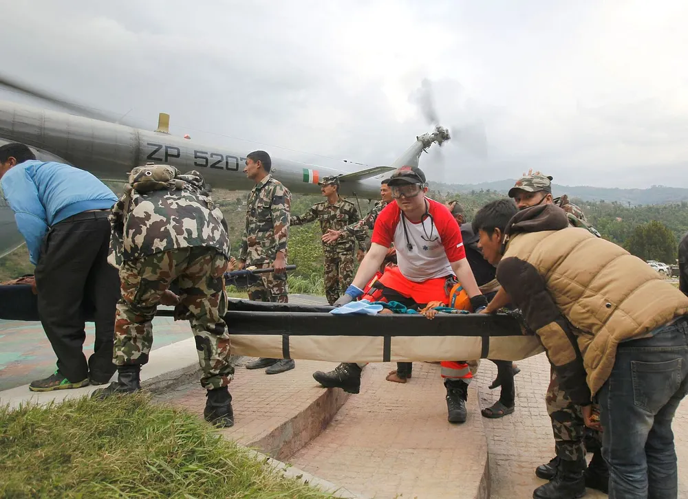 French and Polish rescuers with the Nepalese Army board injured people onto an Indian Air Force helicopter at Melamchi, Nepal, after the 2015 earthquake.