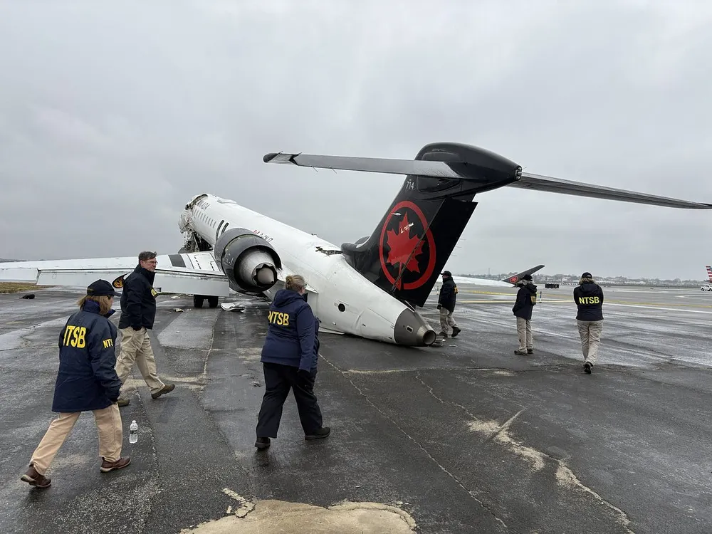 NTSB investigators walk the scene of the 22 March collision between an Air Canada Express plane and a firefighting vehicle on Runway 4 at LaGuardia Airport.