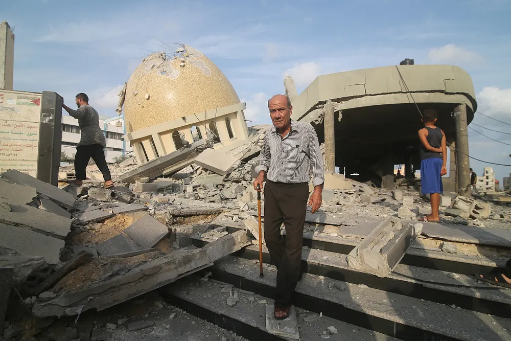 Palestinians inspect a building destroyed in an Israeli airstrike in Khan Yunis, southern Gaza Strip, 8 October 2023.