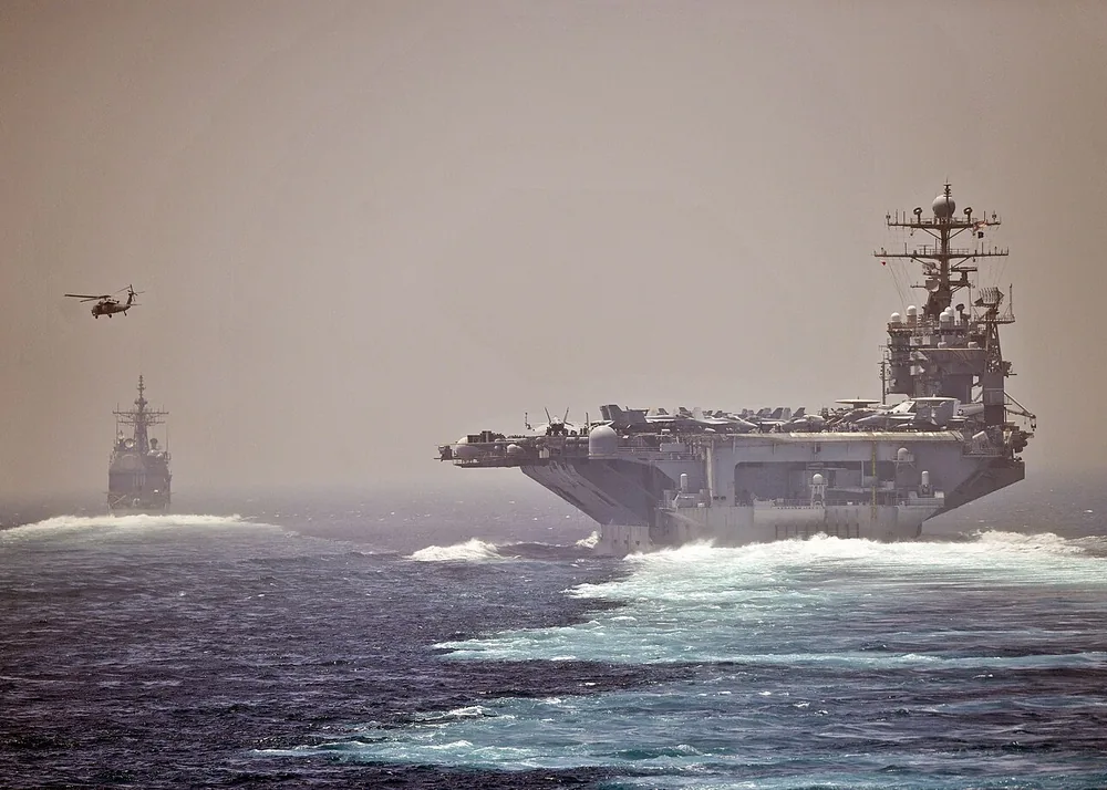 The aircraft carrier USS Abraham Lincoln (CVN 72), left, and the guided-missile cruiser USS Cape St. George (CG 71) transit the Strait of Hormuz.
