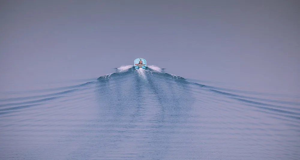A speedboat in the fjords of the Musandam Peninsula, Oman, at the Strait of Hormuz approaches.