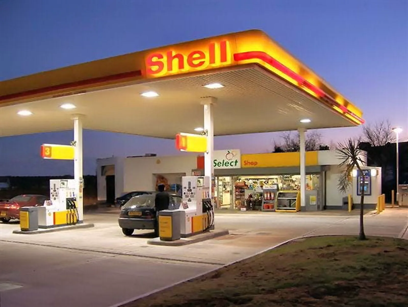 Fuel pumps under a Shell canopy at a filling station at dusk, standing in for diesel near six dollars a gallon