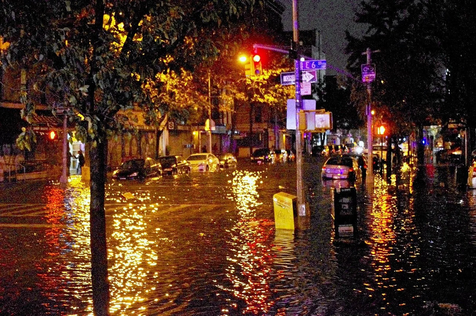 Flooded East Coast street at night after coastal storm surge. A nor'easter killed at least one person and put 6 million
