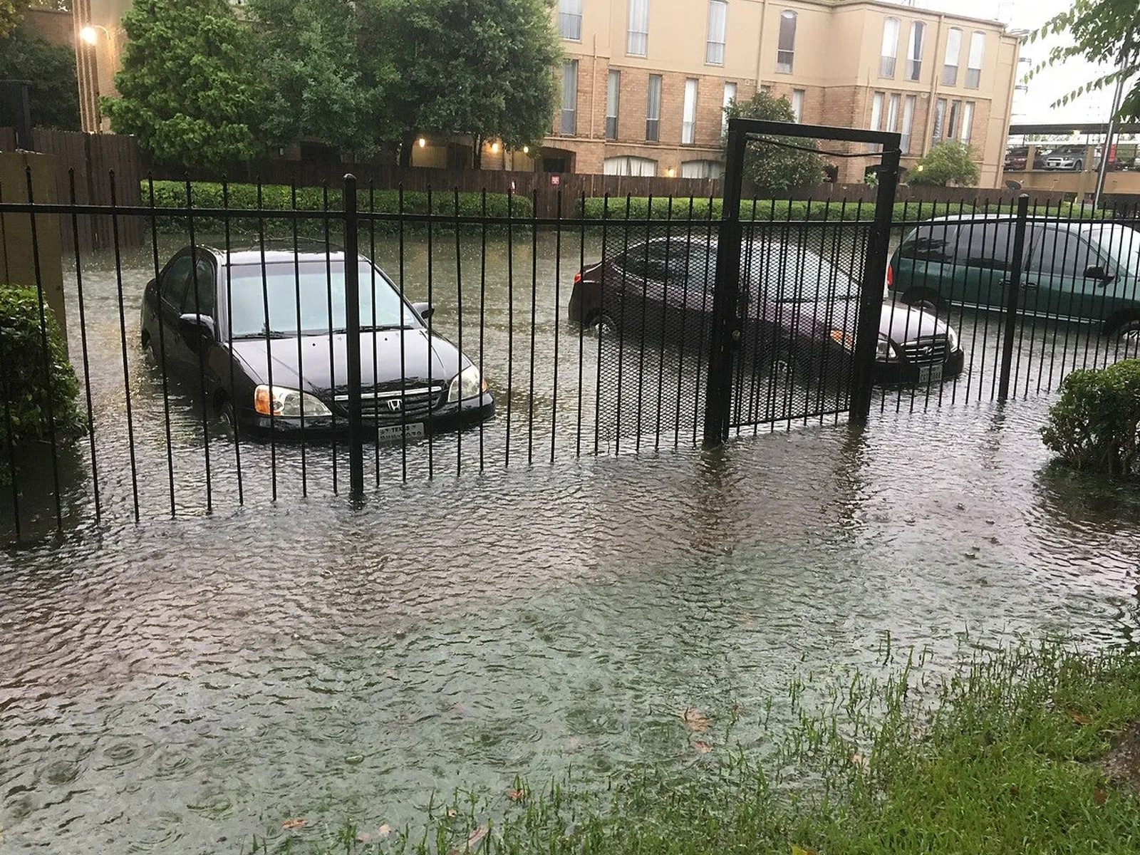 Flooded parking lot and cars after heavy rain in Houston. Texas activated nearly 1,900 flood responders statewide as an